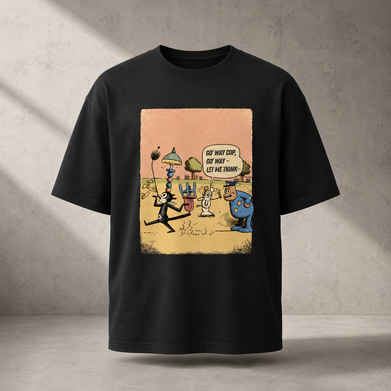 A black short-sleeve t-shirt with a large, colorful cartoon graphic on the front, displayed against a textured gray concrete wall background.