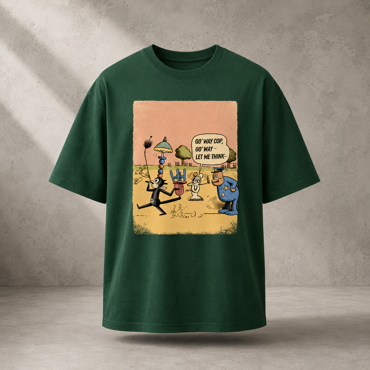 A dark green short-sleeve t-shirt with a large rectangular cartoon graphic on the front, displayed against a textured gray concrete wall background.
