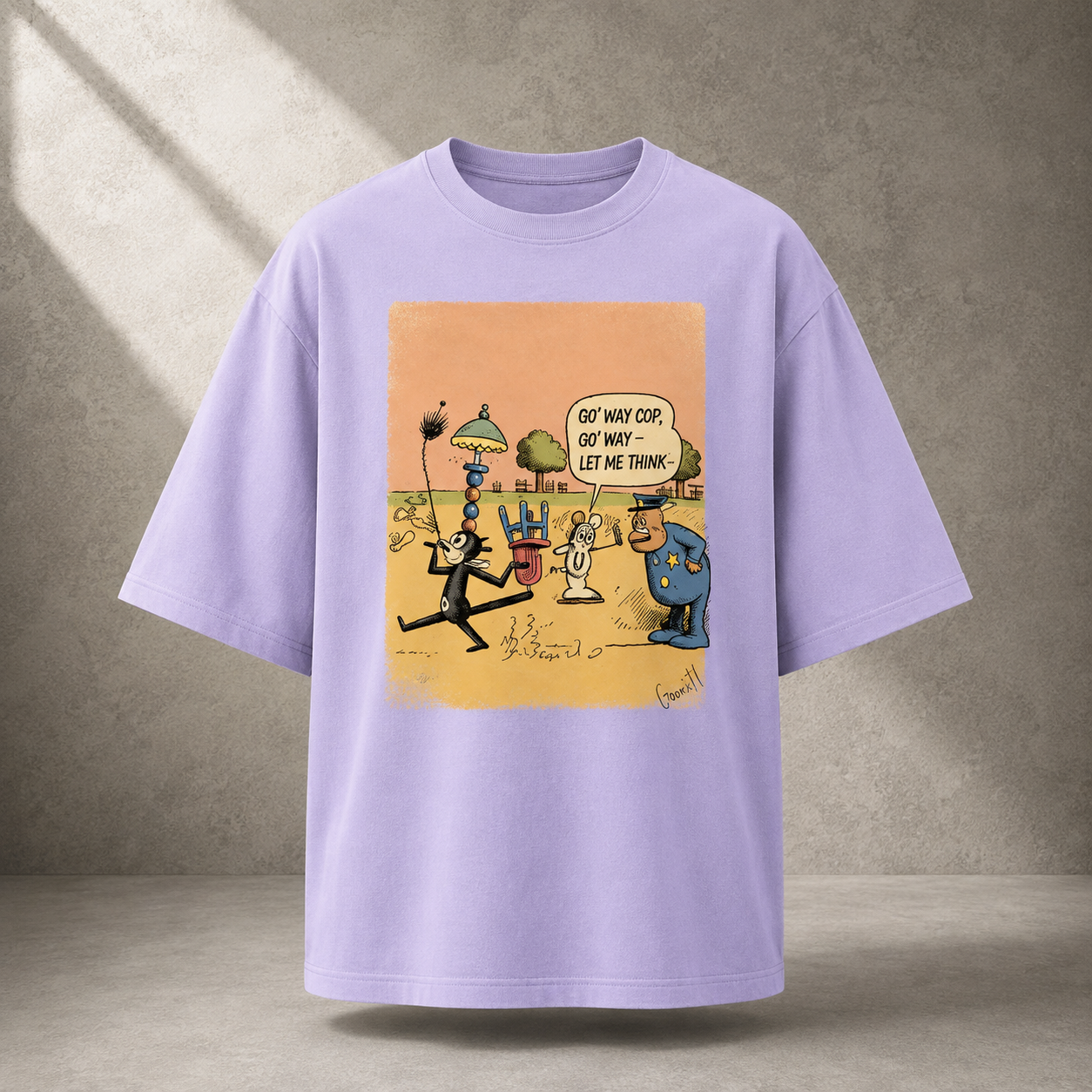 A lavender oversized short-sleeve t-shirt with a colorful cartoon graphic on the front, displayed against a textured gray concrete wall with soft diagonal shadows.