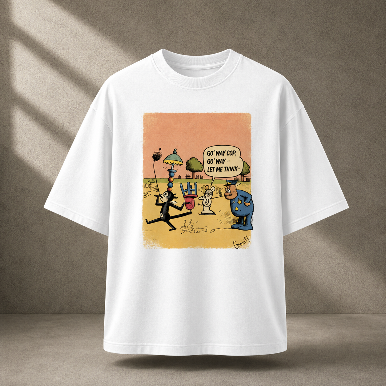 A white short-sleeve t-shirt with a colorful cartoon graphic print on the front, displayed against a textured gray background with soft diagonal shadows.